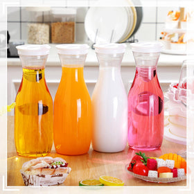 Gejoy 32oz clear pitcher with a tight white cap for secure pouring.