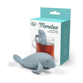 Genuine Fred MANATEA infuser in blue perched on a mug rim for mess-free brewing.