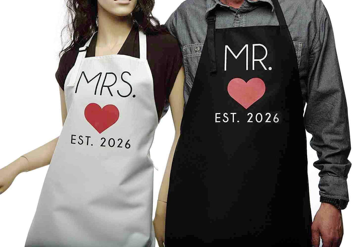 Mr. Est. 2026 and Mrs. Est. 2026 detailing on GSM Brands aprons, sentimental flair