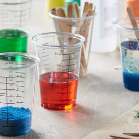 GUSTO clear measuring cups being used in a kitchen for baking and cooking tasks.