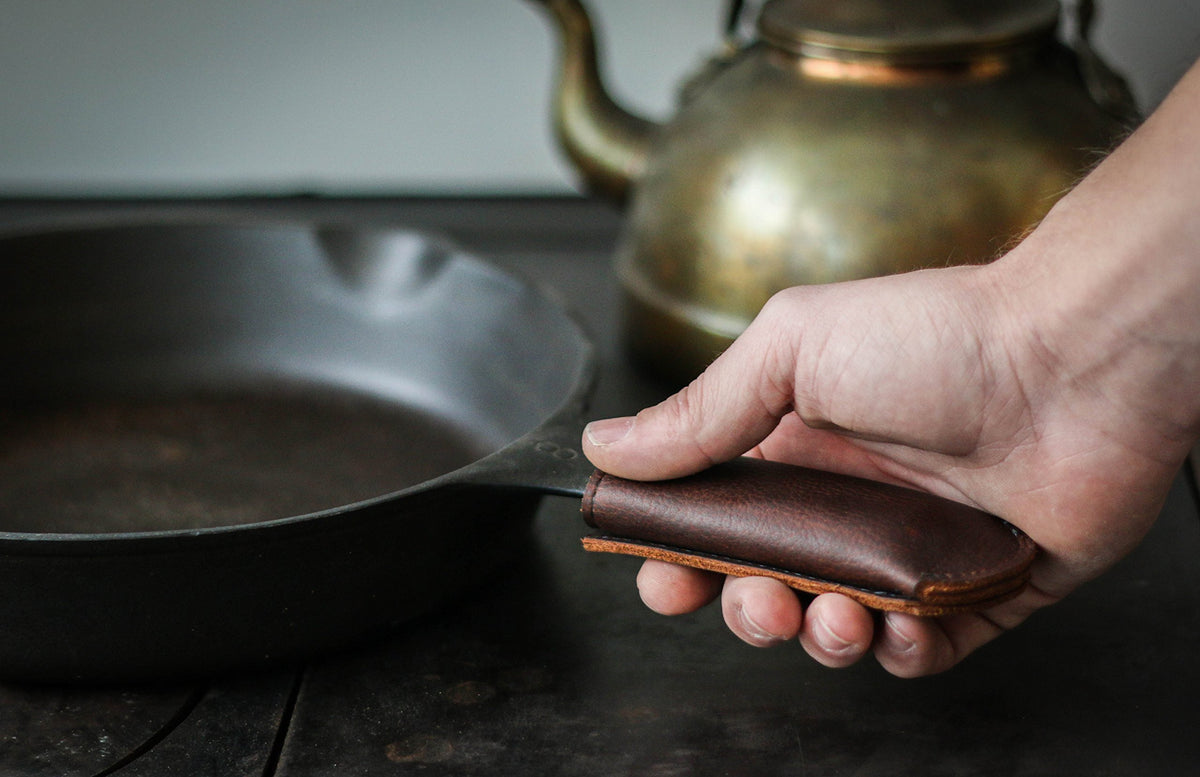 Hardmill leather cover showing ergonomic fit on a cast iron pan handle