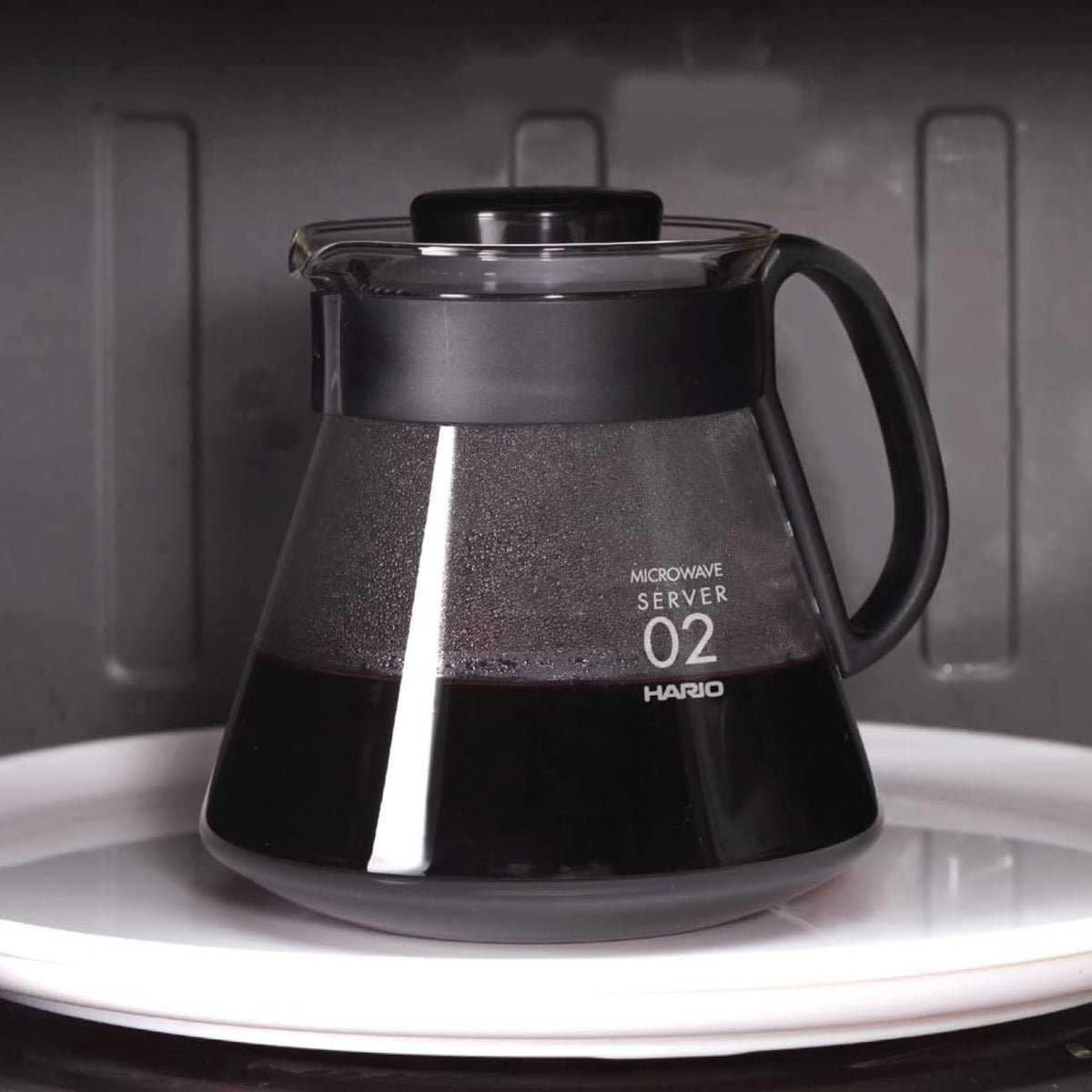 Hario V60 glass range coffee server with lid on, ideal for storing heat.