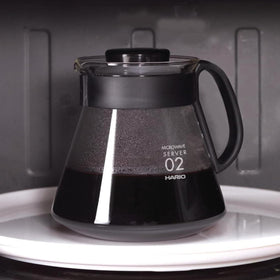 Hario V60 glass range coffee server with lid on, ideal for storing heat.