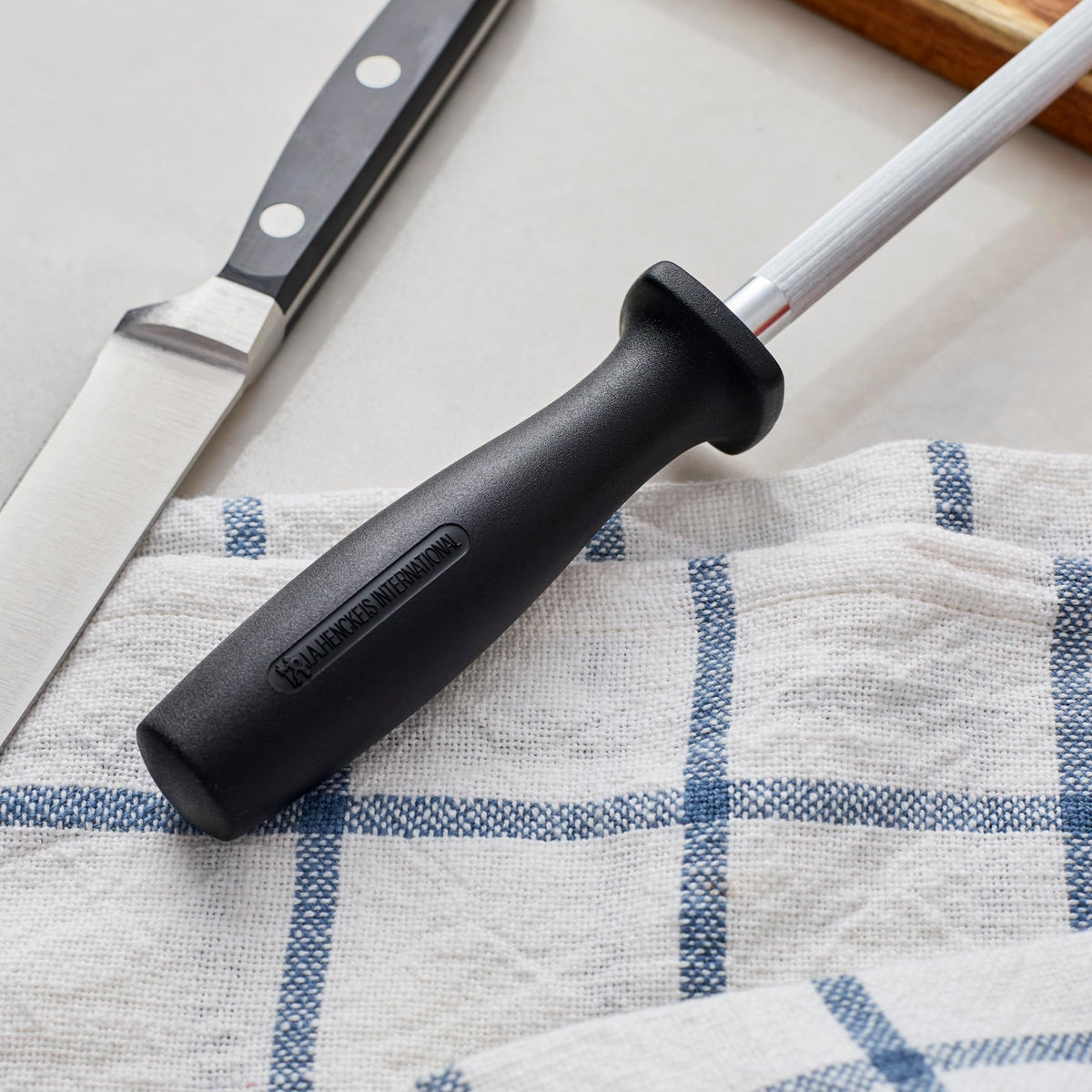 Henckels sharpening steel with ergonomic handle for precise honing.
