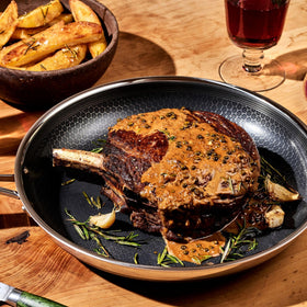 HexClad Hybrid 12-inch pan on the stove with sizzling food for quick, even heating.
