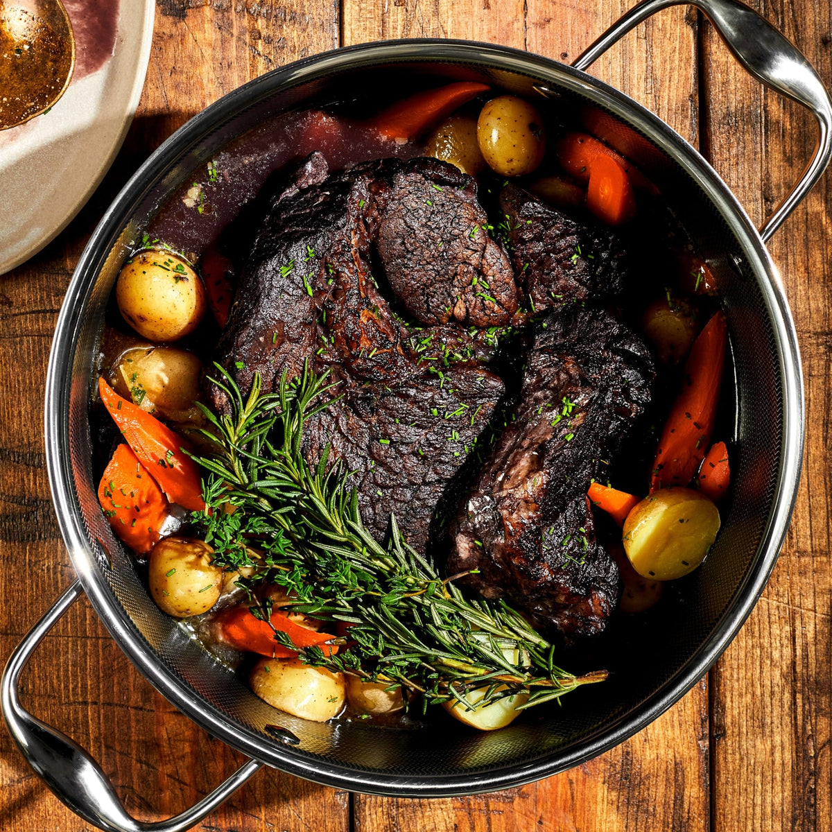 HexClad Hybrid Dutch Oven searing on stovetop for browning.