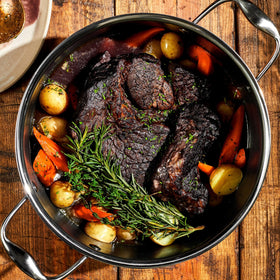 HexClad Hybrid Dutch Oven searing on stovetop for browning.