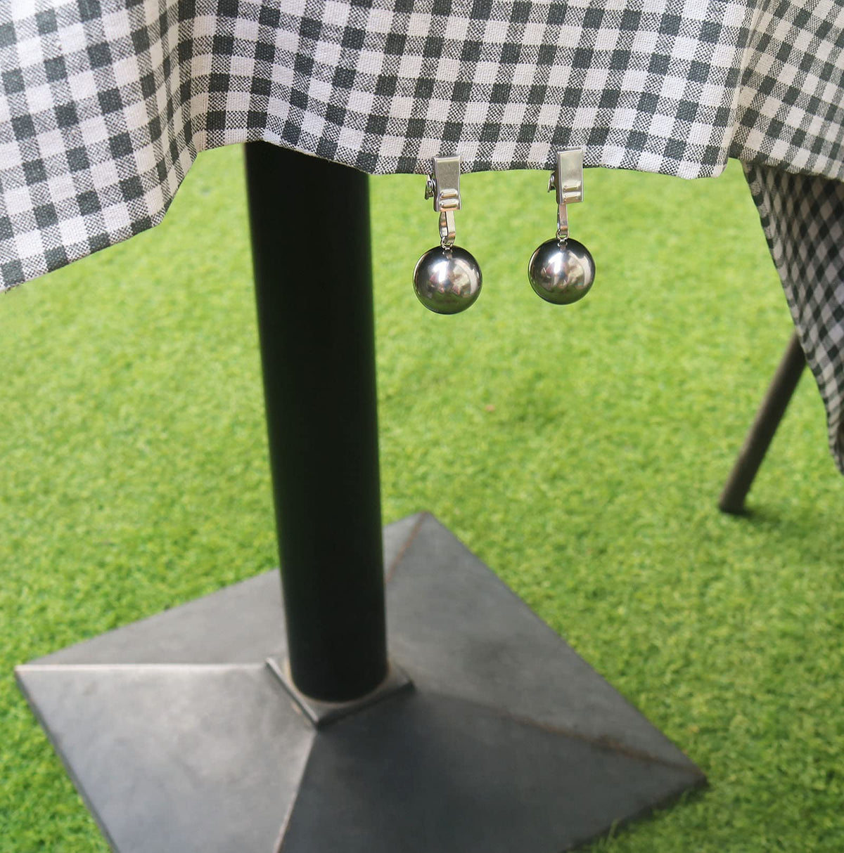 HillSpring weights shown securing an outdoor table cover against wind.