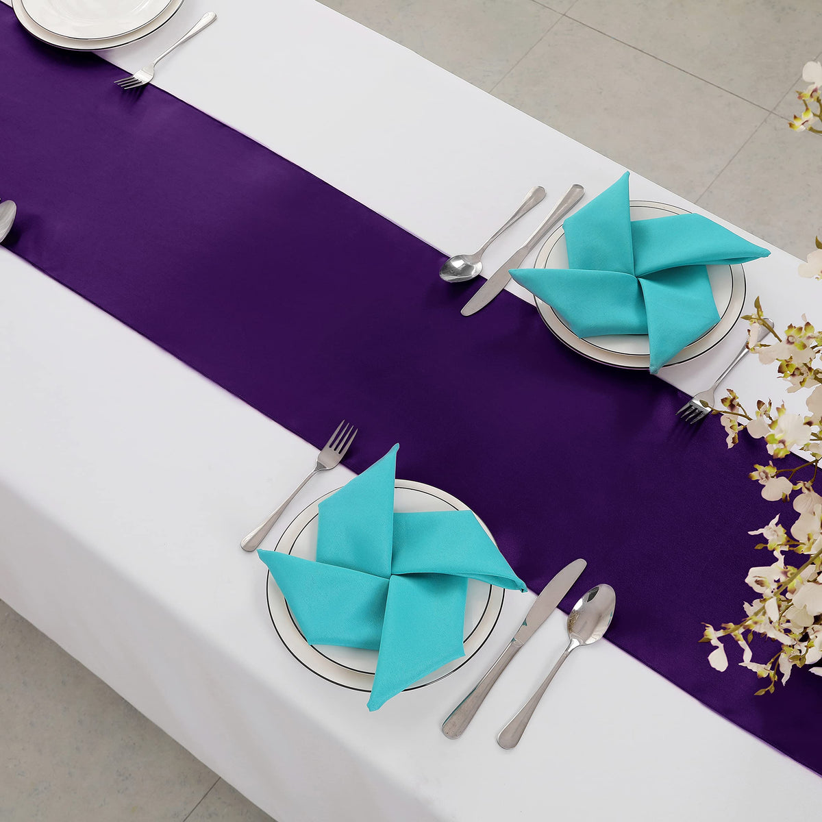 Horbaunal draped satin runner creates a glamorous dining ambiance.