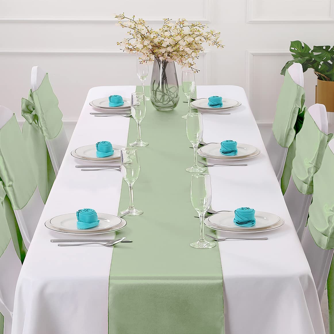 Horbaunal sage green satin runner draped on a table for wedding ambiance and shine.