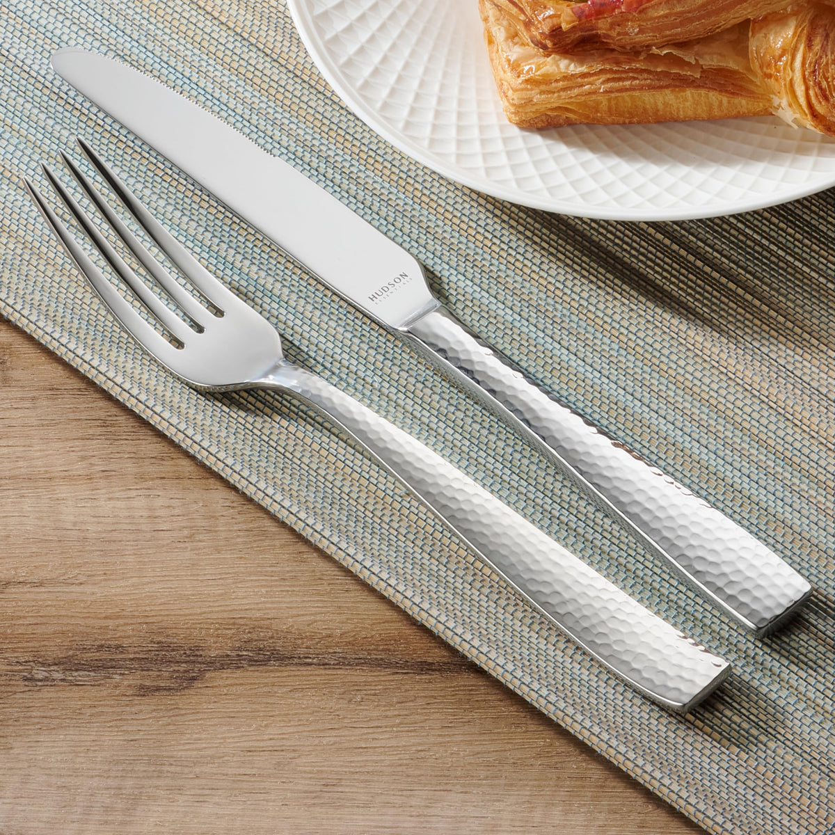 Hudson Essentials hammered flatware on dining table; cohesive look with various tableware.