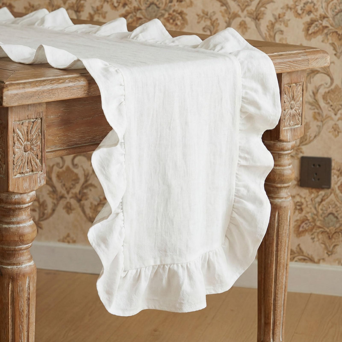 HunnmingRe white ruffled table runner laid across a dining table for festive gatherings