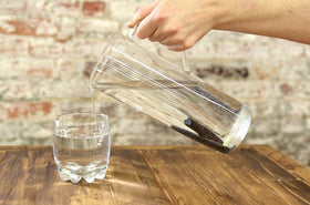 Binchotan sticks filtering water in a carafe by IPPINKA