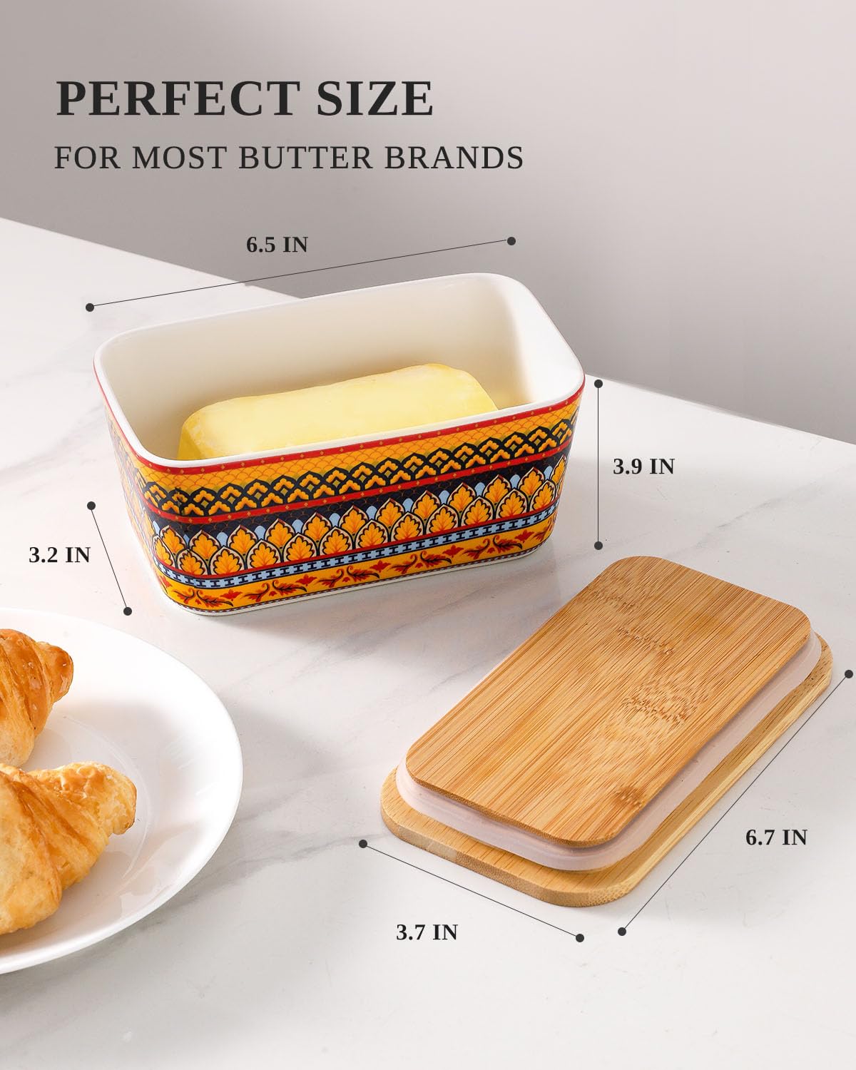JINGUS butter dish on countertop beside bread and fruit with yellow design.