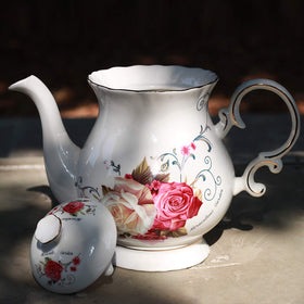Porcelain hand-painted teapot by Jomop with gold trim adds a luxurious touch to gatherings.