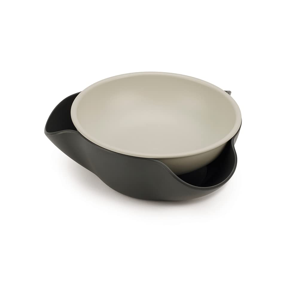 Joseph Joseph Double Dish with pistachio nuts and waste chute for clean, convenient snacking.
