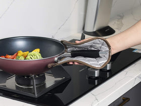 Joyhalo cast-iron pot being removed safely with heat-resistant pads.