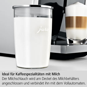 Jura glass milk container attached to coffee machine for convenient use.