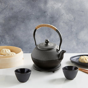 Juvale cast iron teapot on stove for convenient stovetop brewing.