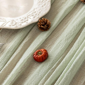 Keketoarrange sage green runner on rustic table for baby shower ambiance.
