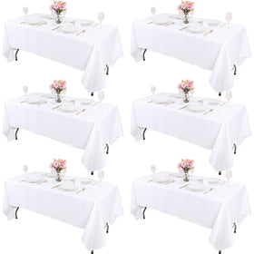 Kesfey 6-pack white tablecloths on a dining table, ready for a dinner party.