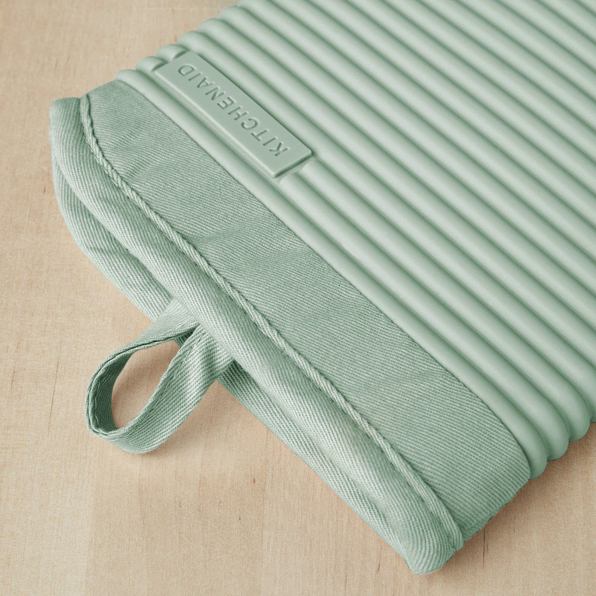 KitchenAid heat-resistant silicone mitts withstand up to 500°F for safe pan transfers.