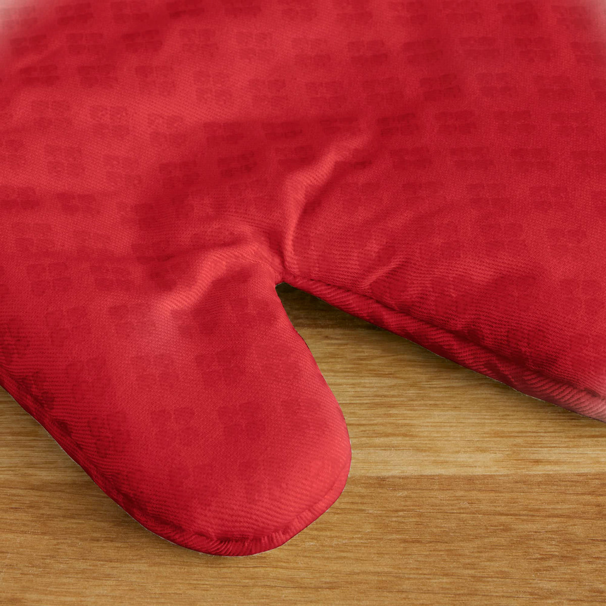 KitchenAid Asteroid oven mitts fire red exterior made of cotton fabric for insulation.
