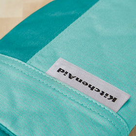 KitchenAid Beacon oven mitt Aqua Sky in use for removing a baking dish from the oven.