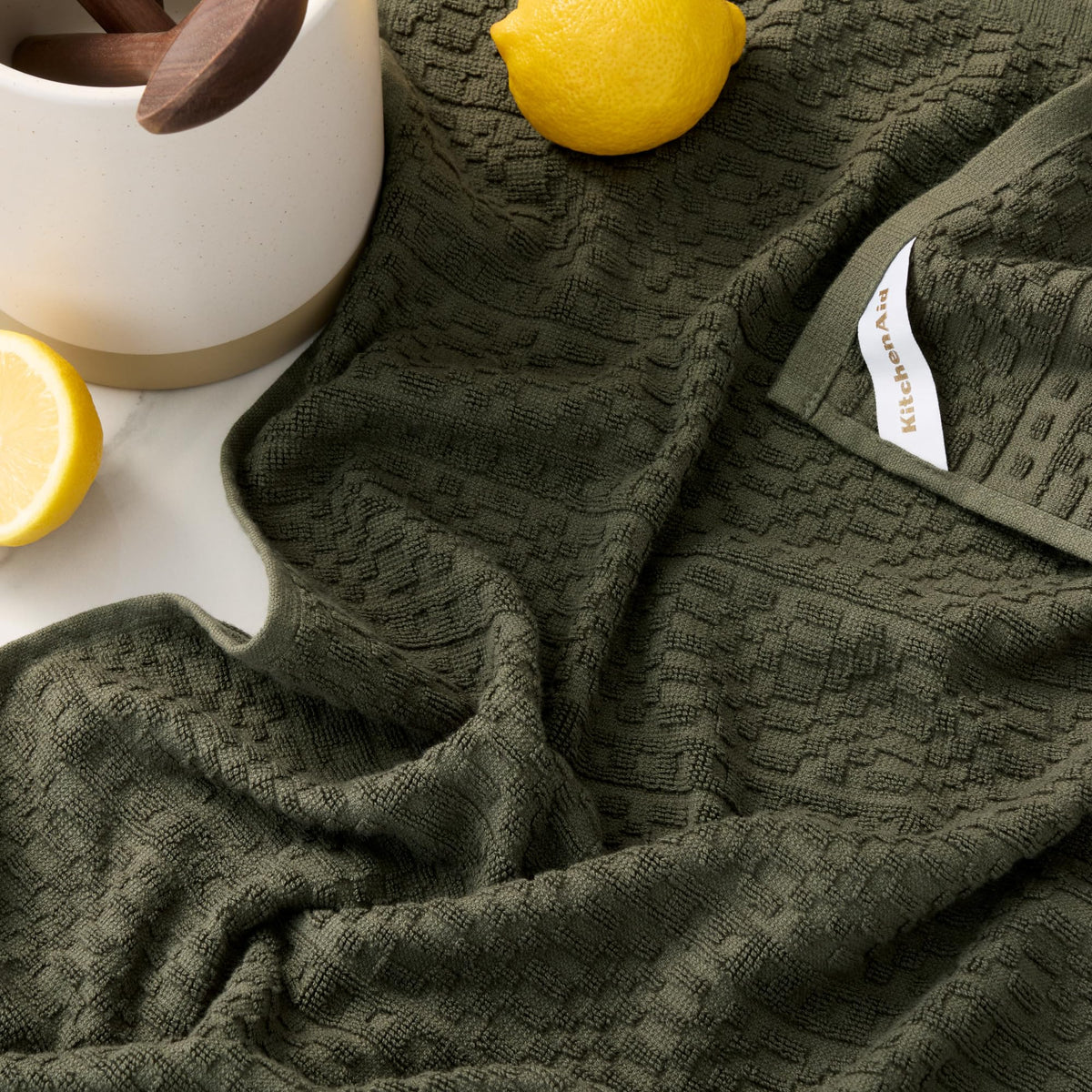 KitchenAid Evergreen dual-sided towel showing absorbency on one side and lint-free drying.