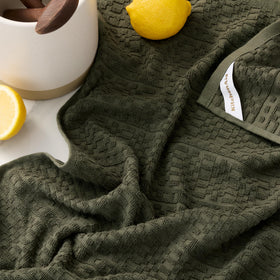 KitchenAid Evergreen dual-sided towel showing absorbency on one side and lint-free drying.