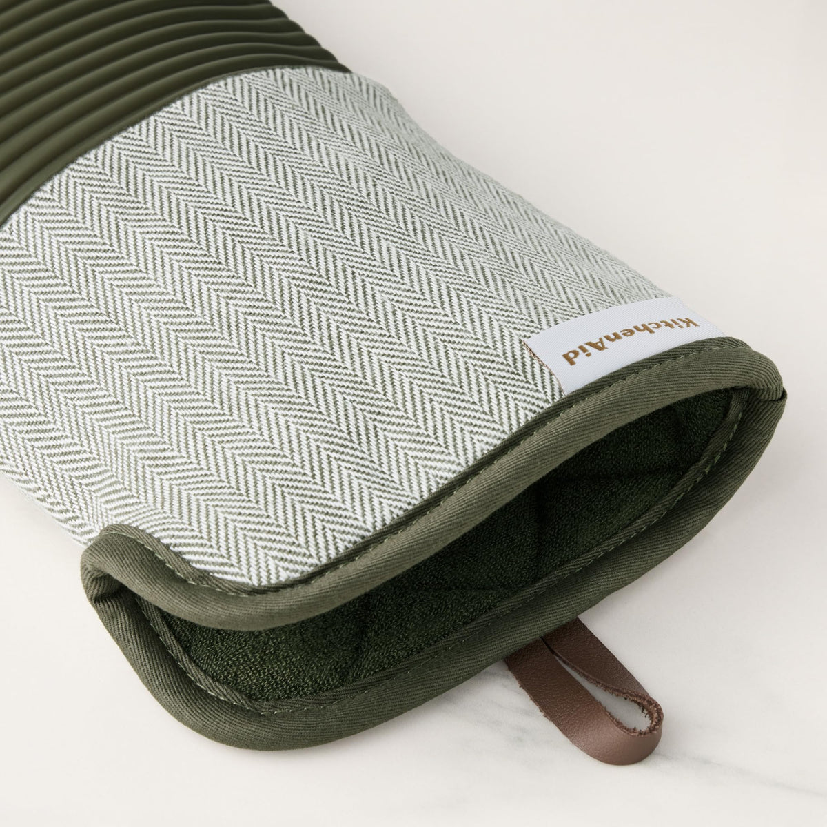 KitchenAid Evergreen oven mitts in use lifting a hot pot
