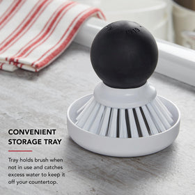KitchenAid palm brush with storage dish to catch drips and protect countertops.