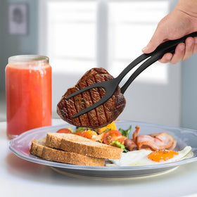 KJG egg flipping tongs in action on a hot pan.