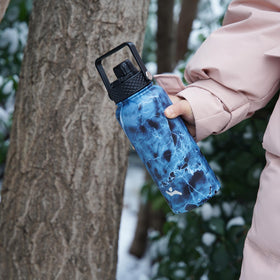 Person using Konokyo bottle on the go during outdoor activity