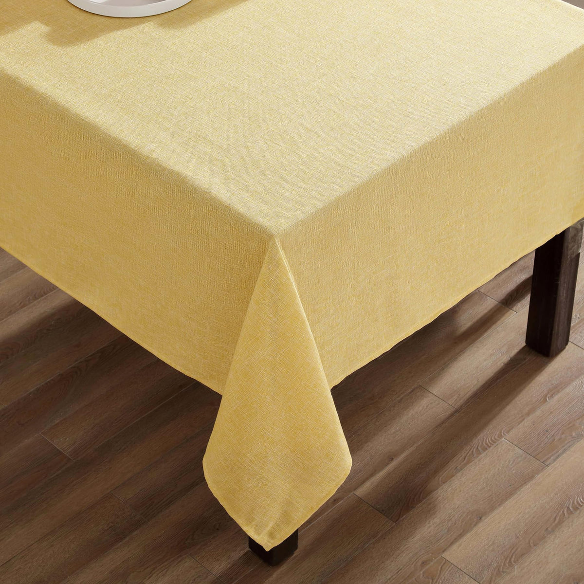 Laura Ashley Harper tablecloth protects the table surface with a warm yellow tone.