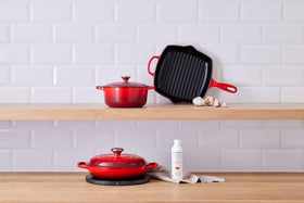 Le Creuset cleaner applied on enameled cast-iron surface for stain removal