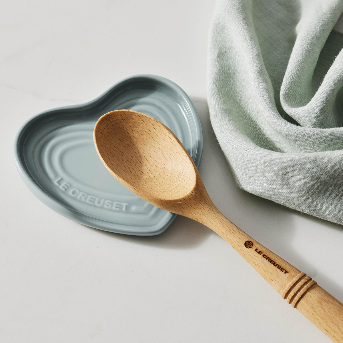 Le Creuset spoon rest in cerise, dishwasher-safe for easy cleaning.