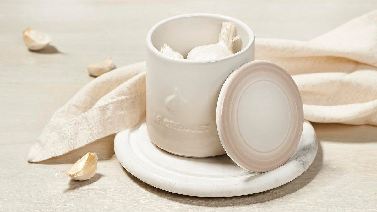 Le Creuset garlic keeper meringue with open lid, showing inner surface for quick prep.