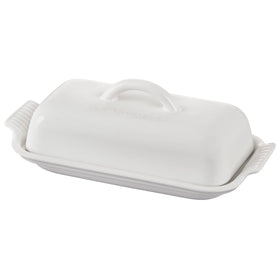 Le Creuset Heritage butter dish on table with glossy glaze for easy serving.