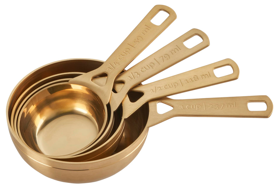 Le Creuset gold finish measuring cups in 1/4 cup for precise ingredient portions.
