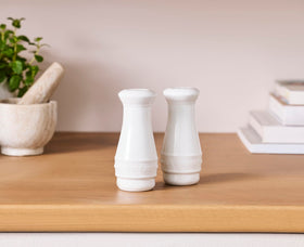 Le Creuset salt and pepper shakers in a kitchen scene, compact 4-ounce size.
