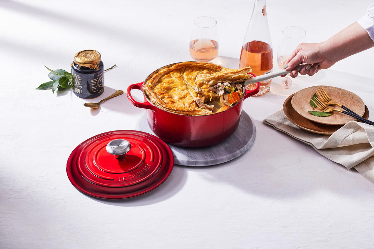 Ergonomic handles and stainless steel knob on Le Creuset Cerise Dutch oven
