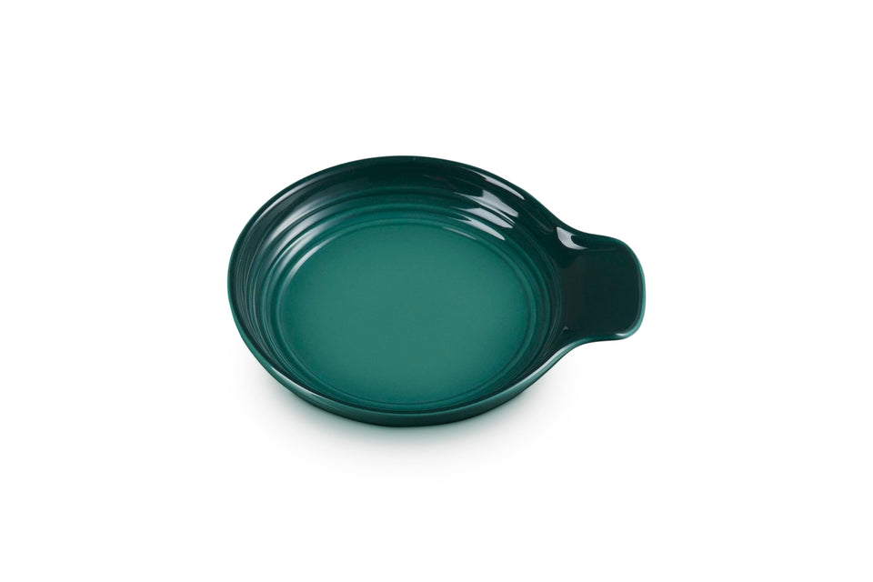 Le Creuset Signature spoon rest in Artichaut glaze keeps countertops tidy during cooking.