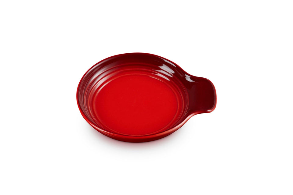 Le Creuset Signature spoon rest in cerise keeps utensils off the counter for easy cleanup.