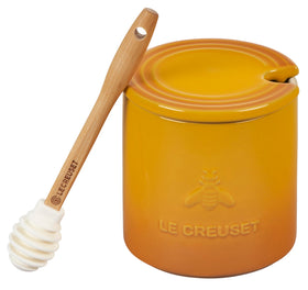 Le Creuset Nectar stoneware honey pot with dipper on countertop, keeps honey within reach.