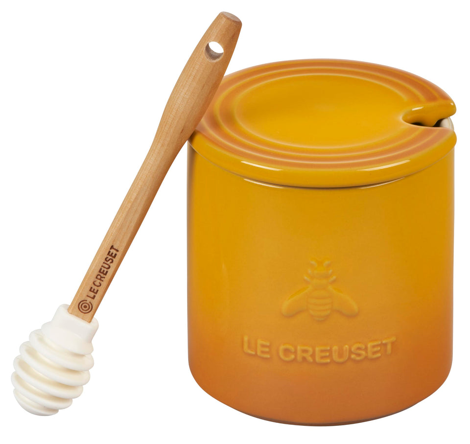 Le Creuset Nectar stoneware honey pot with dipper on countertop, keeps honey within reach.