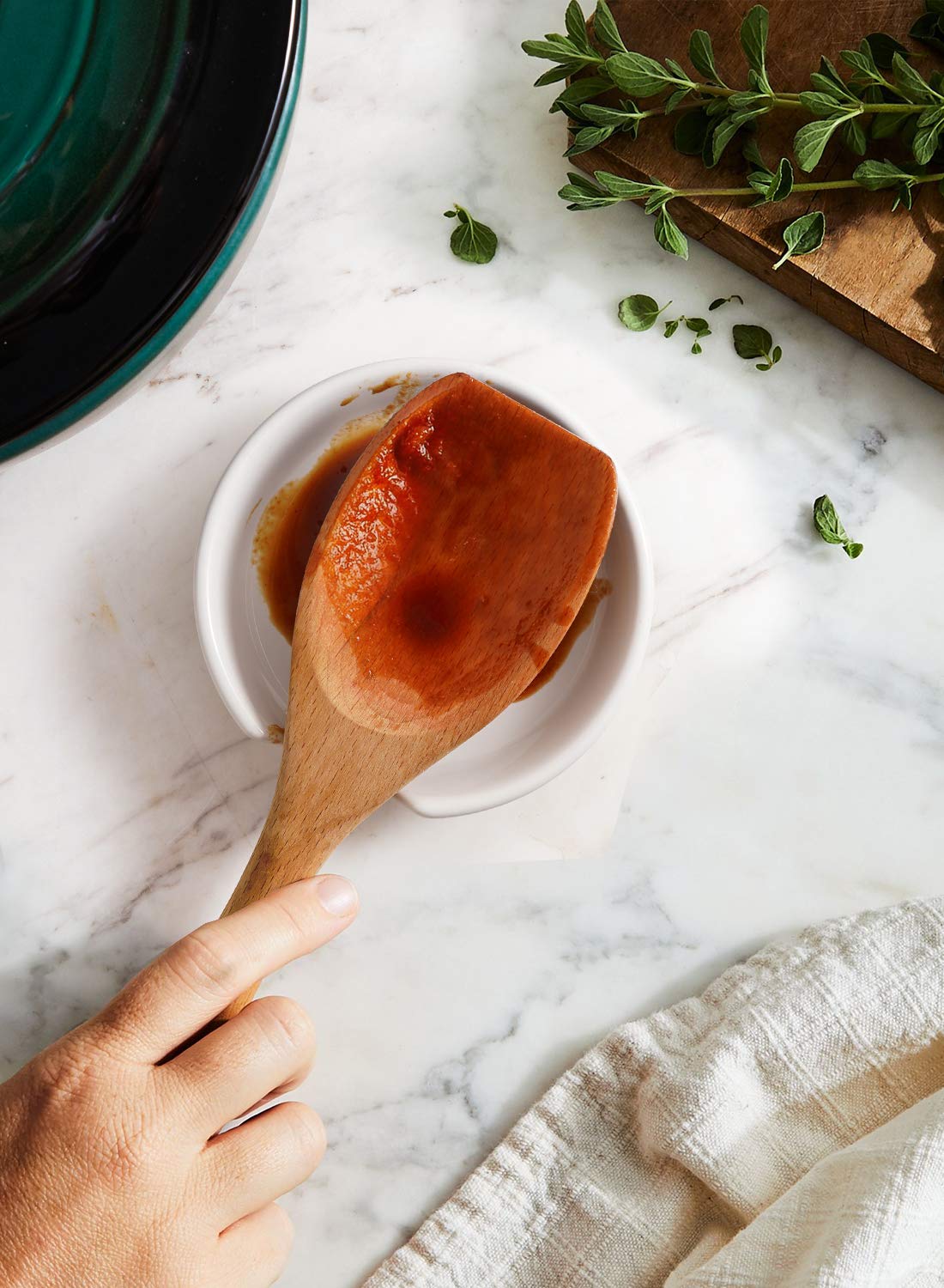 LE TAUCI white spoon rest on counter for easy cleanup.