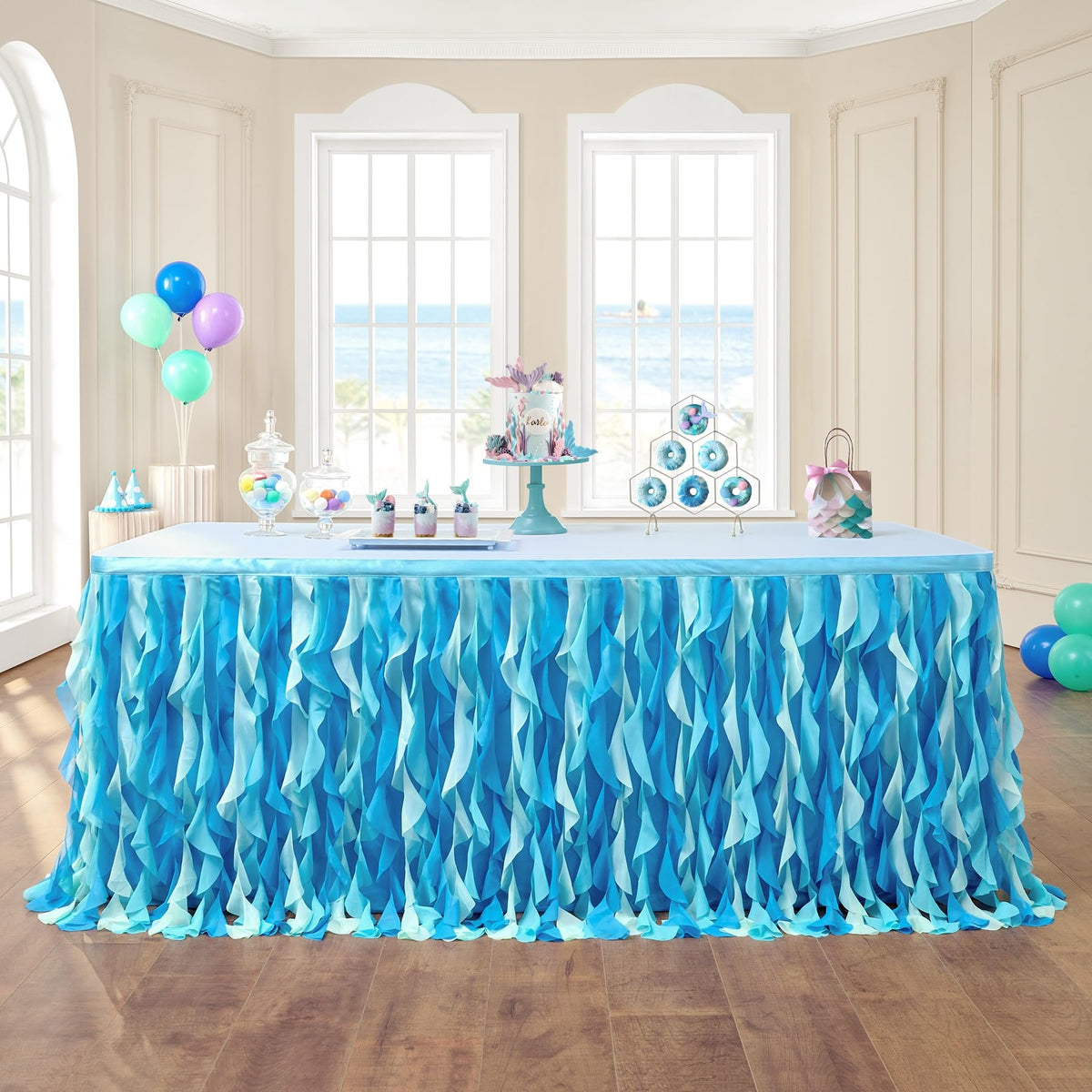 Leegleri 6ft tulle table skirt in ocean blue over a rectangle table for a festive setup.