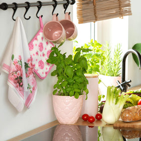 Leinuosen pink rose kitchen-use scene shows hands handling hot dish.