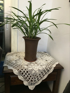 Lelefly beige decor accent pairs with candles and flowers for a warm table setting.